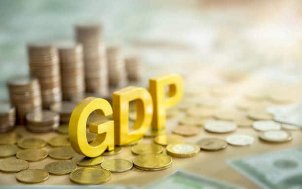 Pendapatan Nasional: Definisi, Jenis dan Manfaatnya 1 Huruf GDP kuning berdiri di antara tumpukan koin dan uang kertas yang melambangkan pertumbuhan ekonomi.